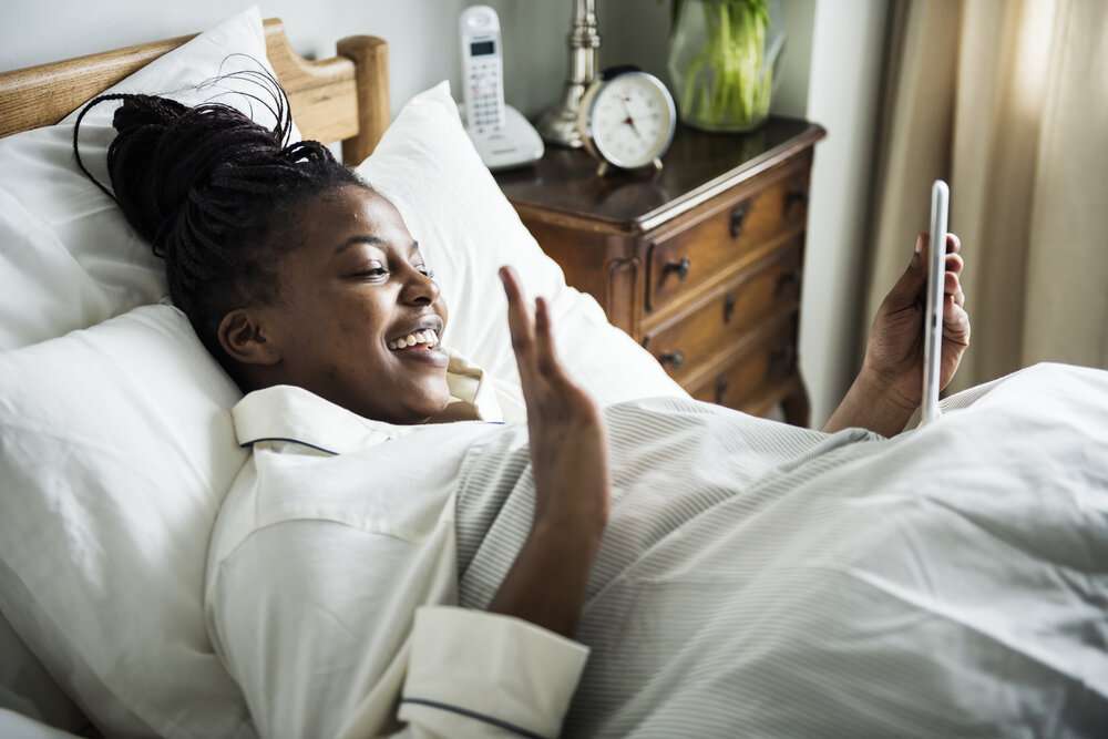 The Love Central - A woman during a video call in bed The Love Central -