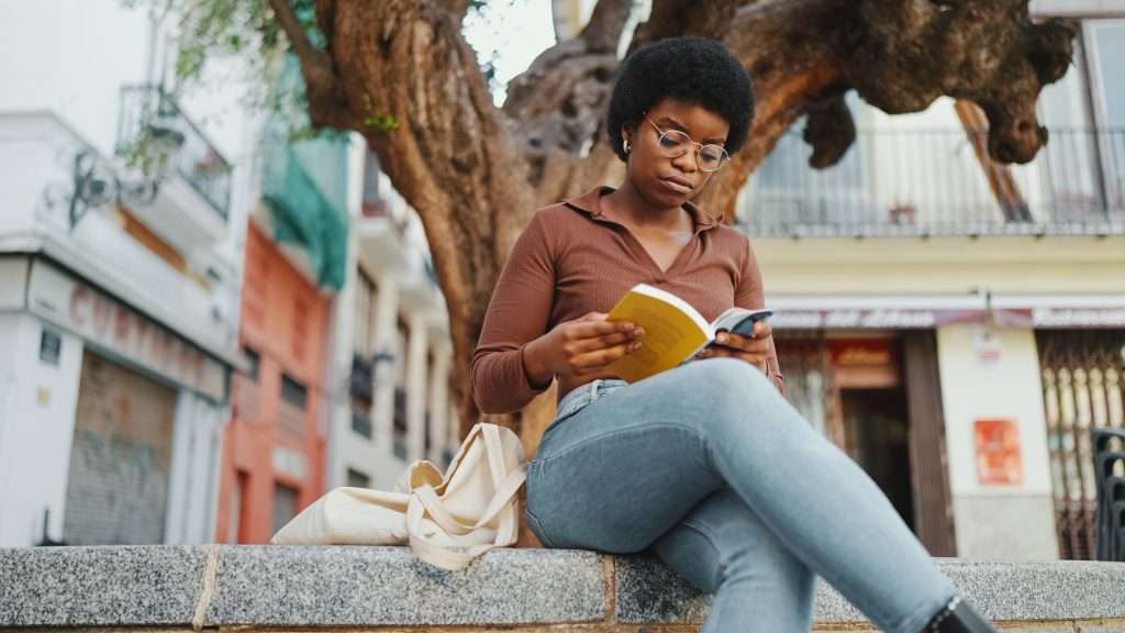 The Love Central - Young African woman looking concentrated while reading a book un Today, African diaspora literature continues to evolve