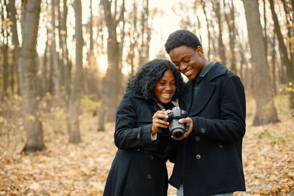 The Love Central - Black couple walking in park and looking in camera in their hand Art offers a special platform for couples to engage in meaningful dialogue
