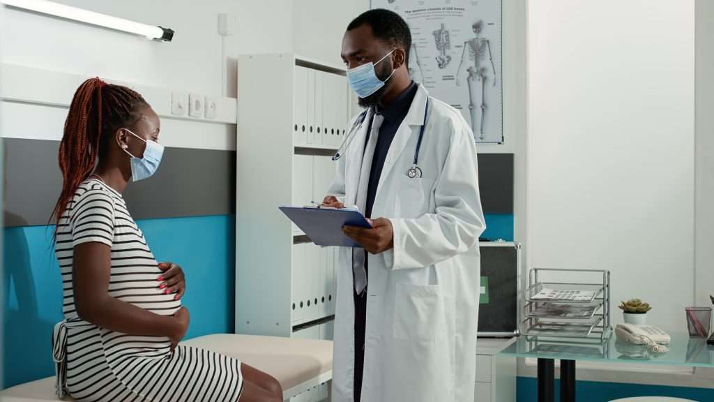 The Love Central - African american medic and pregnant patient meeting at appointment It is important to seek professional help