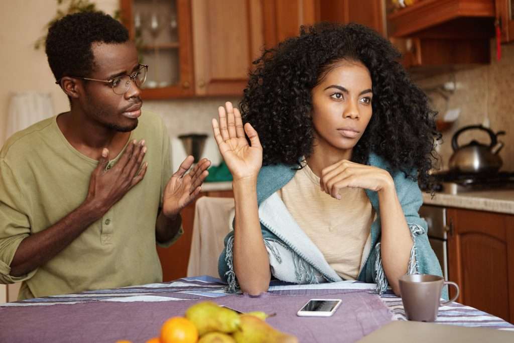 The Love Central - Sad African-American male in glasses holding hand on chest apologizing to his angry and mad wife who ignoring him refusing to forgive him for cheating on her People and relationships concept It’s normal to be scared of being rejected, but that fear should not stop us from expressing our regret.
