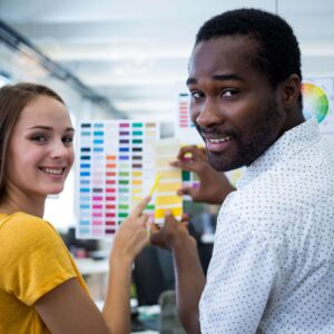 The Love Central - Male and female graphic designers interacting over color chart The Love Central - One crucial aspect that often gets overlooked is choosing the right wedding colors