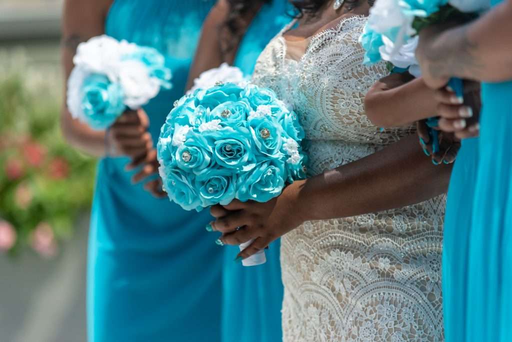 The Love Central - Closeup shot of the bride and her bridesmaids standing and holding bouquets no faces captured The Love Central -