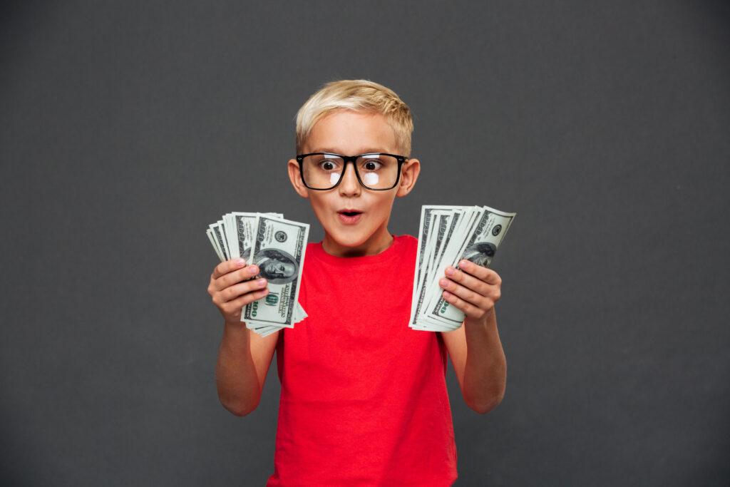 The Love Central - Screaming surprised little boy child showing money. The Love Central -