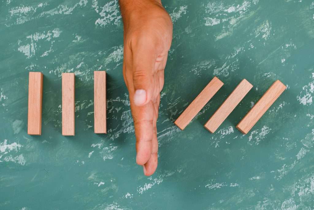 The Love Central - Solution and insurance concept on plaster background flat lay. hand barrier dividing wooden blocks. The Love Central -