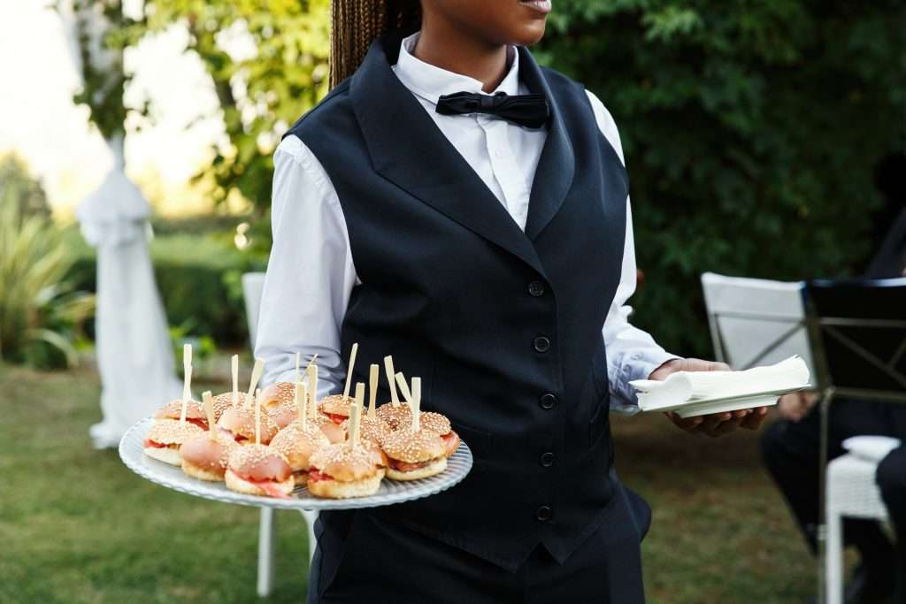 The Love Central - Waiter carries plate with tasty snacks The Love Central -
