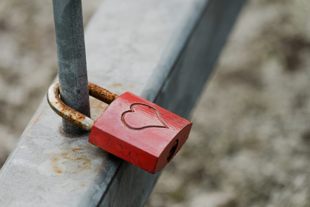 The Love Central - Closeup shot of a metal padlock with a heart hanging on a fence The Evolution of Valentine’s Day: How People Celebrate Love in Different Cultures and Contexts