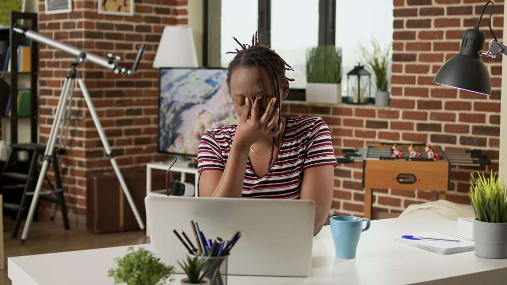 The Love Central - Stressed businesswoman with headache working remotely A stressed