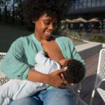 The Love Central - A smiling mother breastfeeding vher baby