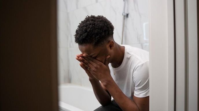 A guy crying in the bathroom.