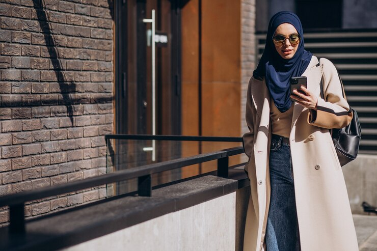 A muslim woman pressing her phone