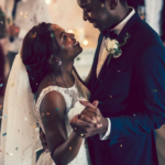 The Love Central - Black couple dancing and laughing on their wedding day.