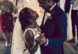 Black couple dancing and laughing on their wedding day.