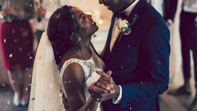 Black couple dancing and laughing on their wedding day.