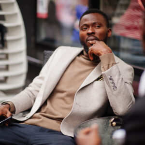 The Love Central - Two fashion black men sitting outdoor with mobile phone. Fashion The Love Central -