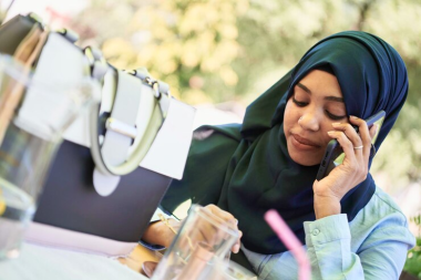 A muslim lady answering a phone call.