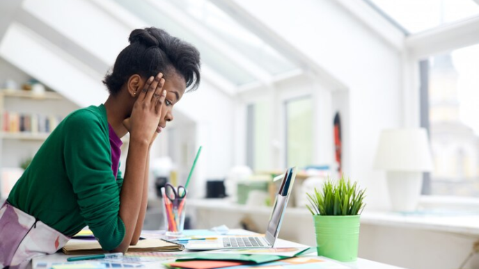 A lady fully concentrating on her laptop device.