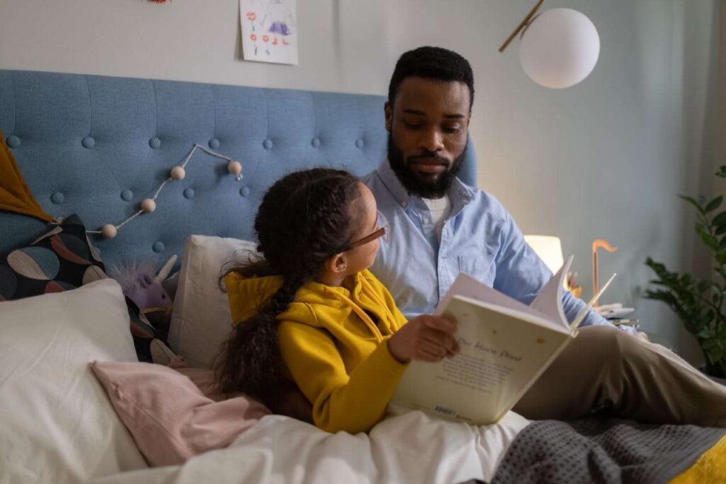African father reading to his daughter.