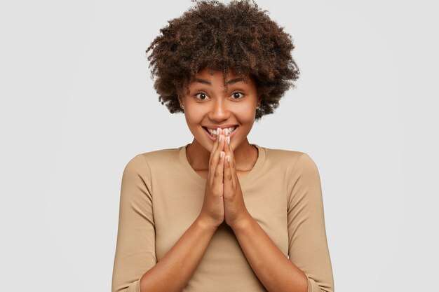 The Love Central - emotive-pleased-dark-skinned-girl-has-toothy-smile-keeps-hands-praying-gesture_273609-44973 The Love Central -