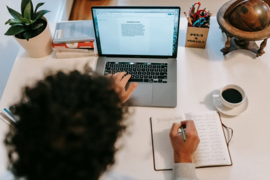A lady with her laptop and writing materials.