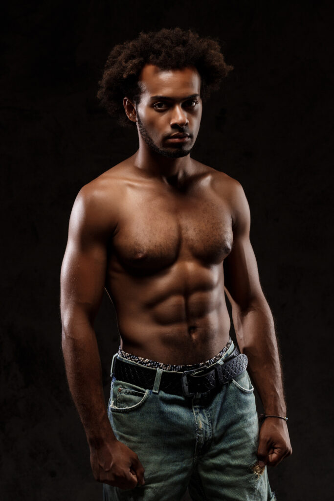 The Love Central - Young sportive african man posing over black background. The Love Central -