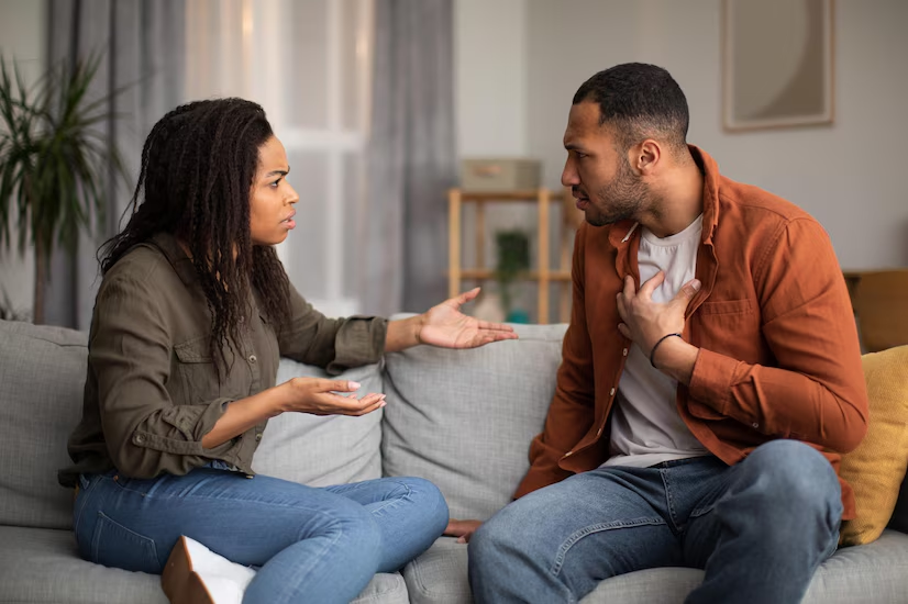 The Love Central - Master the Art of Conflict Resolution: The 10-Minute Rule The Love Central - Angry Black Couple Having Quarrel Sitting On Sofa At Home