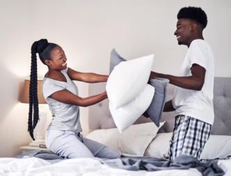 Couple playing with pillows on the bed