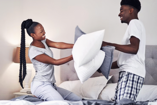 Couple playing with pillows on the bed
