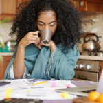 The Love Central - A lady calculating her finances while drinking coffee