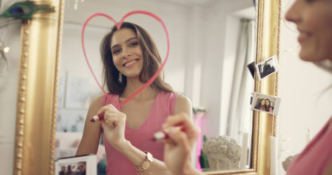 A lady drawing a heart on a mirroe