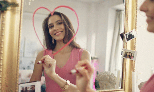 A lady drawing a heart on a mirroe