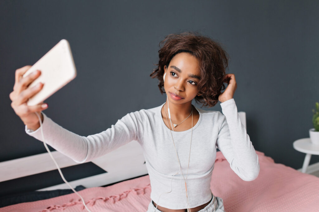 The Love Central - Young girl taking selfie on bed The Love Central -